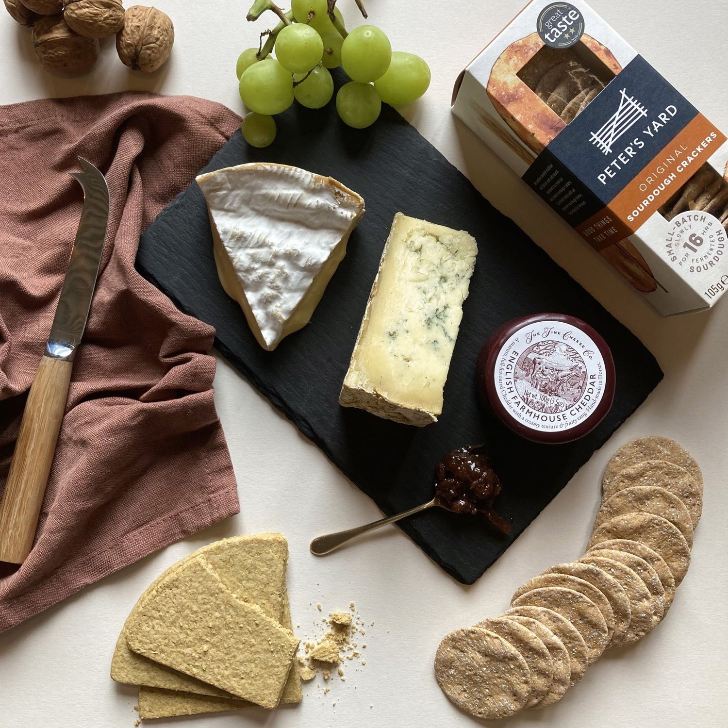 A sharing platter of British cheese, crackers, chutney and grapes.